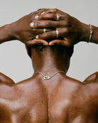 Man with muscular back and hands on head against a neutral background, 925 silver men's jewelry necklace