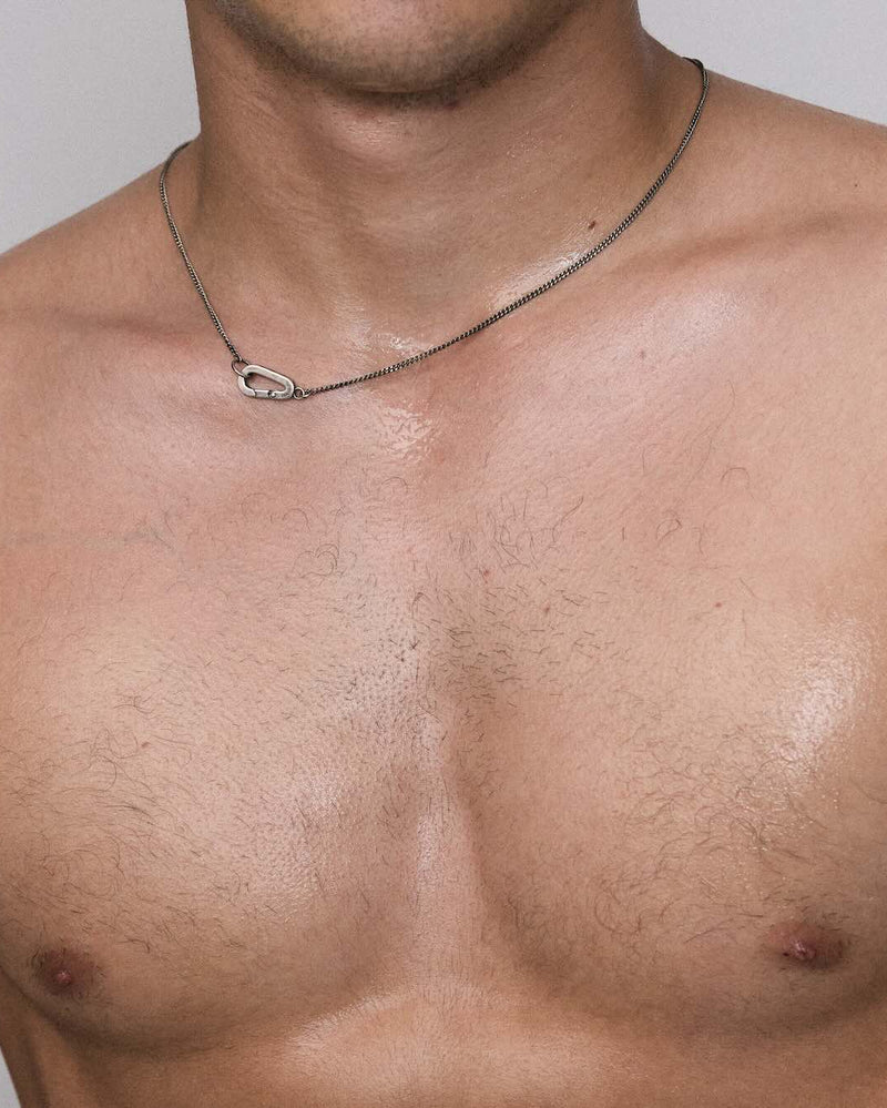 Man with a necklace on a plain background