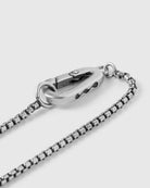 Close-up of a silver chain necklace on a light gray background, 925 silver men's jewelry necklace