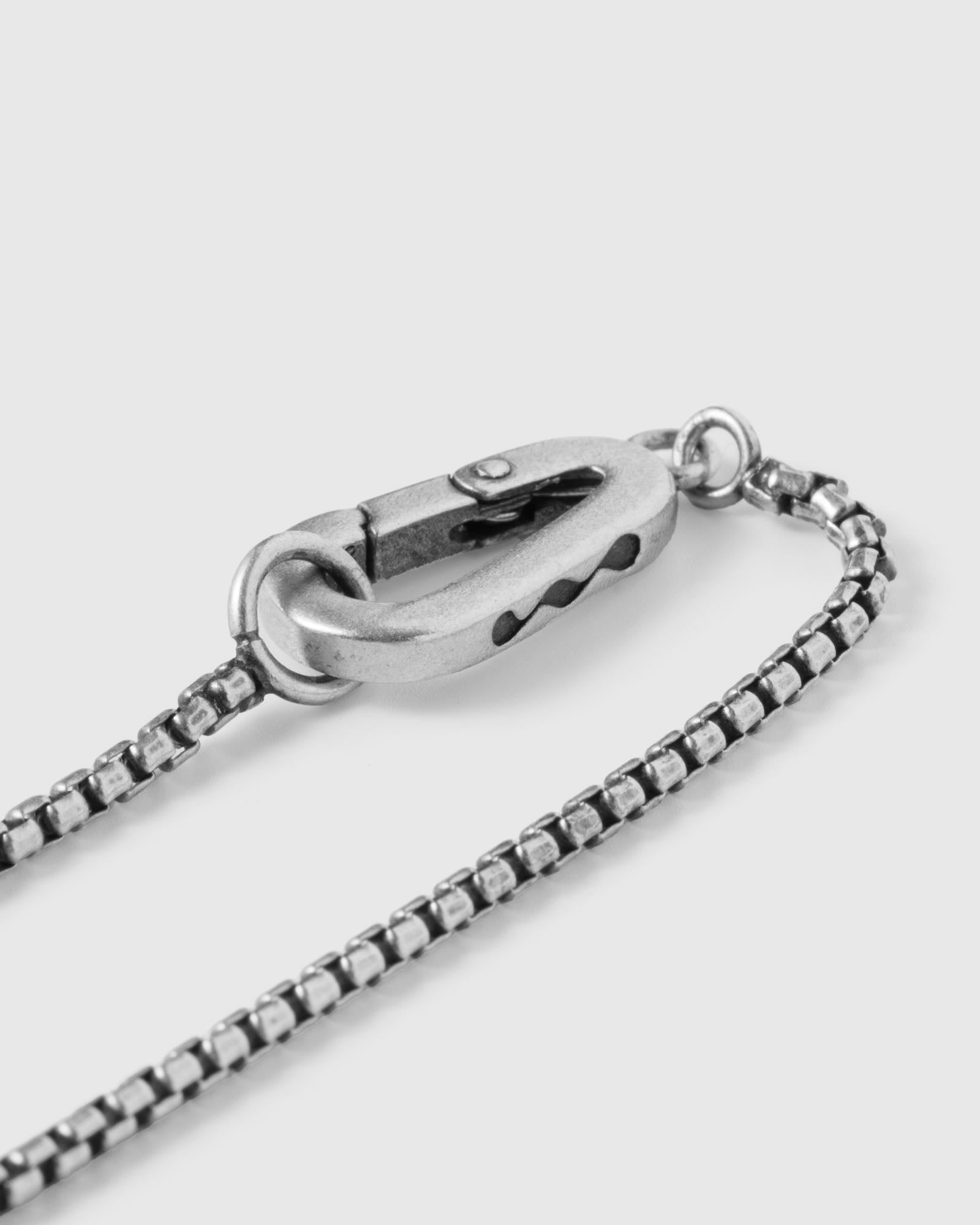Close-up of a silver chain necklace on a light gray background, 925 silver men's jewelry necklace