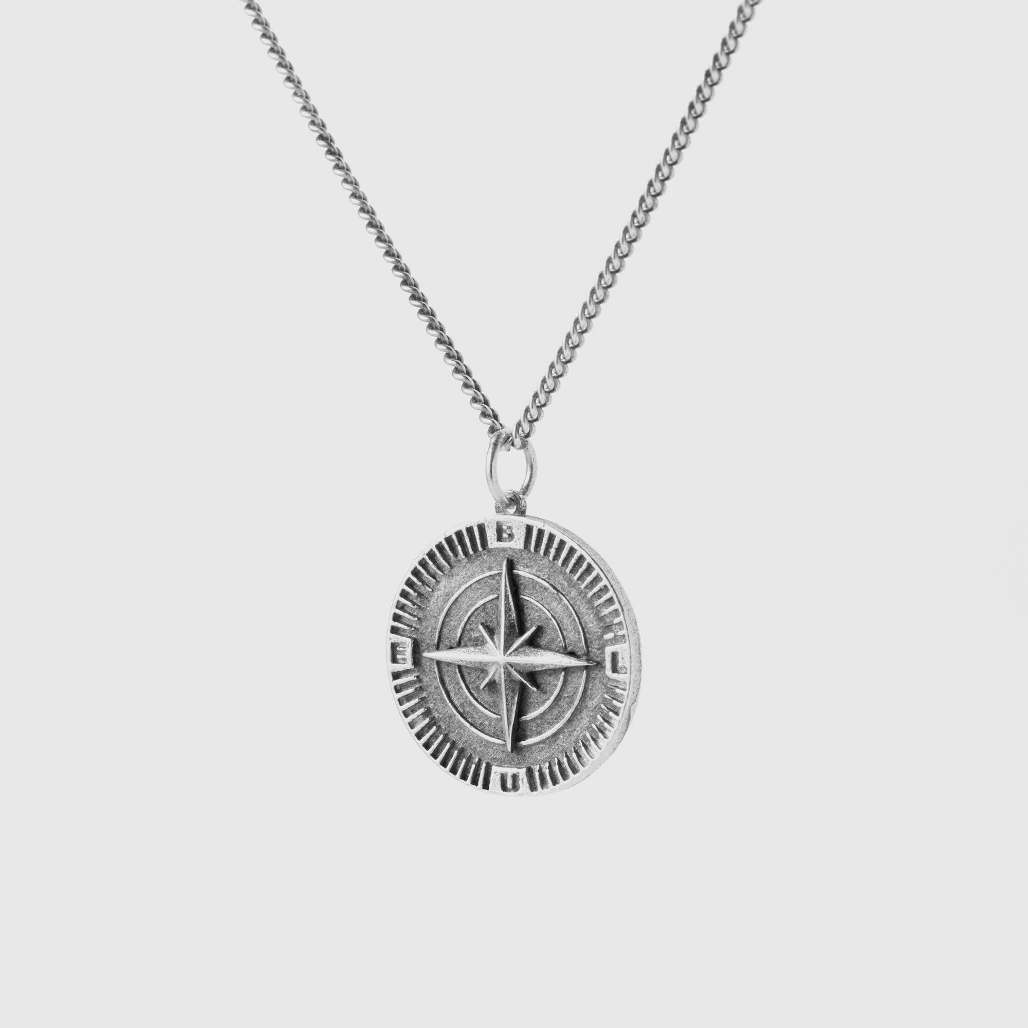 Silver compass pendant necklace on a light gray background 925 silver neckace