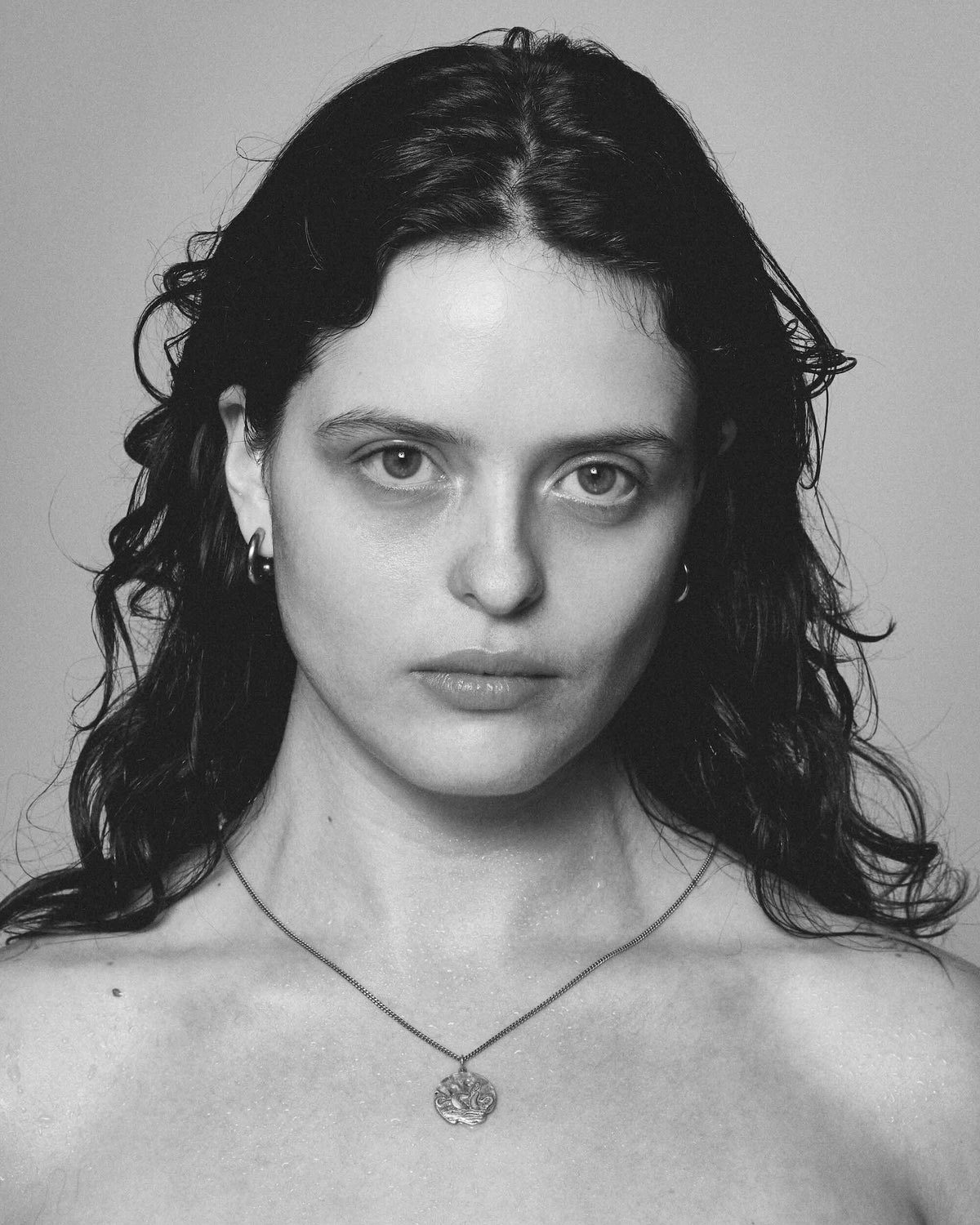 Black and white portrait of a woman with wet hair against a plain background wearing 925 silver necklace women