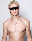 Man with sunglasses and a necklace against a plain background wearing 925 silver