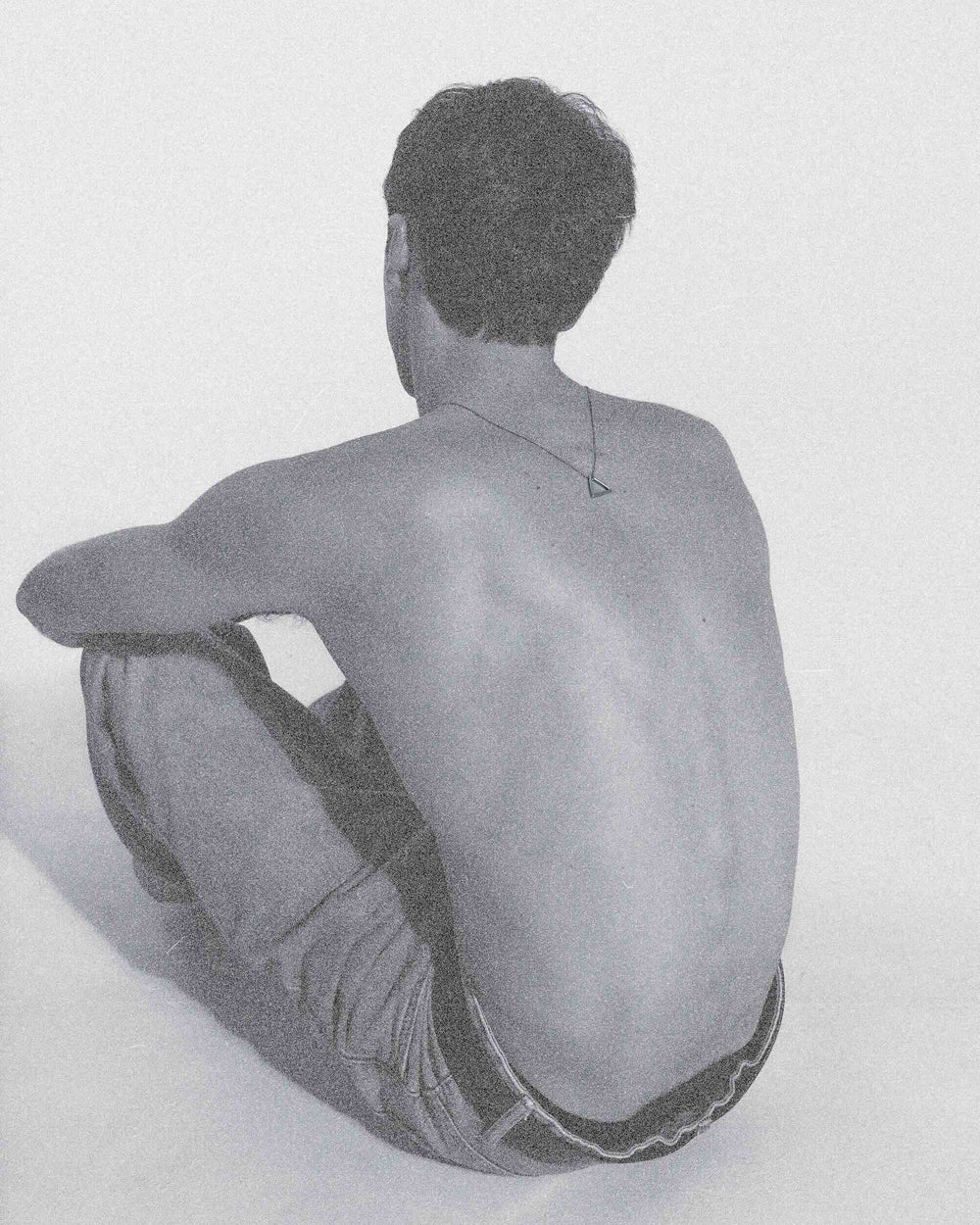 Person sitting on a white background with a minimalistic approach