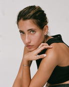 Woman wearing a black sleeveless top against a plain background wearing 925 silver blue serpent rings